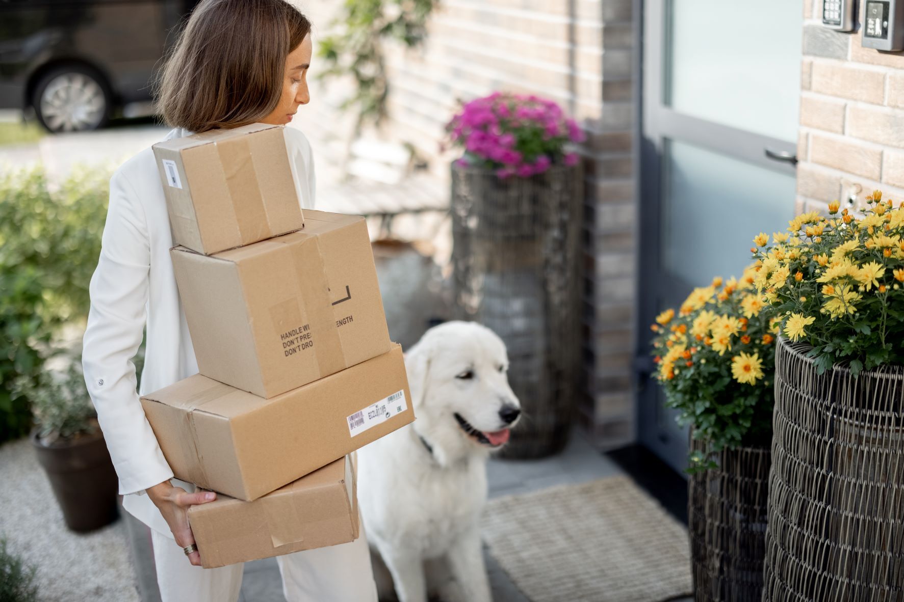 Woman with a pile of parcels and dog on the porch 