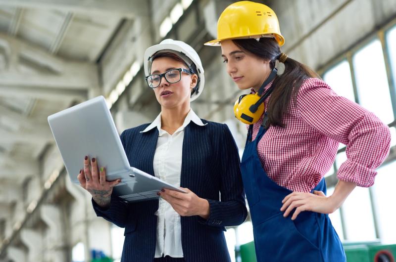 manufacturing technicians conferring data on laptop